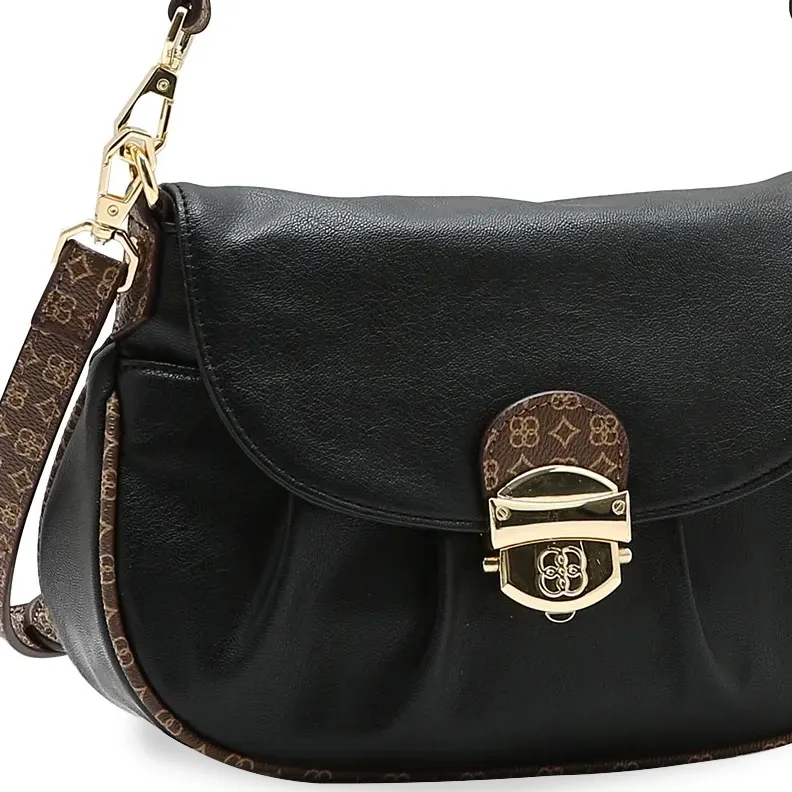 Close no fecho dourado e textura da bolsa Chenson preta com detalhes em monograma